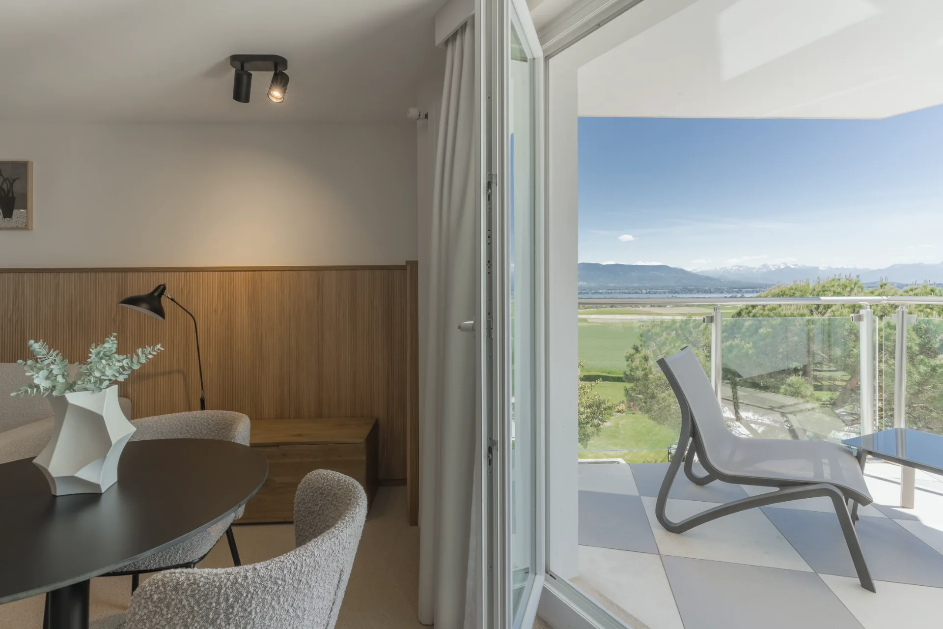 Suite d'hôtel avec terrasse et vue sur lac et montagnes enneigées